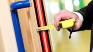 measuring gap on fire door during inspection
